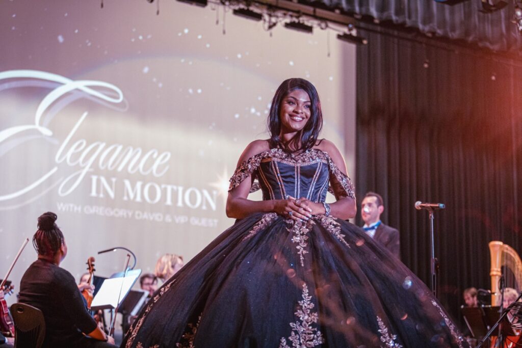 A guest in a dramatic ball gown on stage