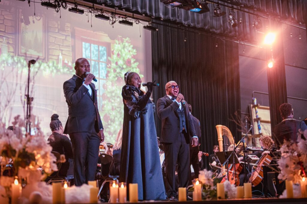 Three performers in tuxedos and a gown